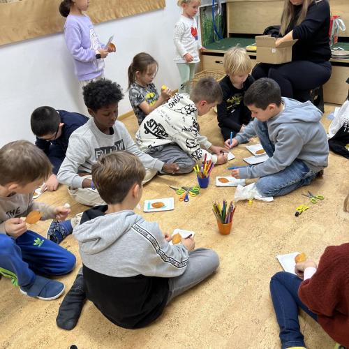 Kinder am Boden beim Gestalten von Bildern 