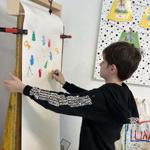 Kind beim Geschenkpapier stempeln 