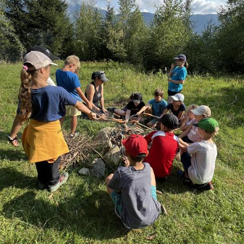 Kinder beim Würstel grillen im Wald