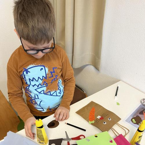 Kind beim Ostersäckchen bekleben 