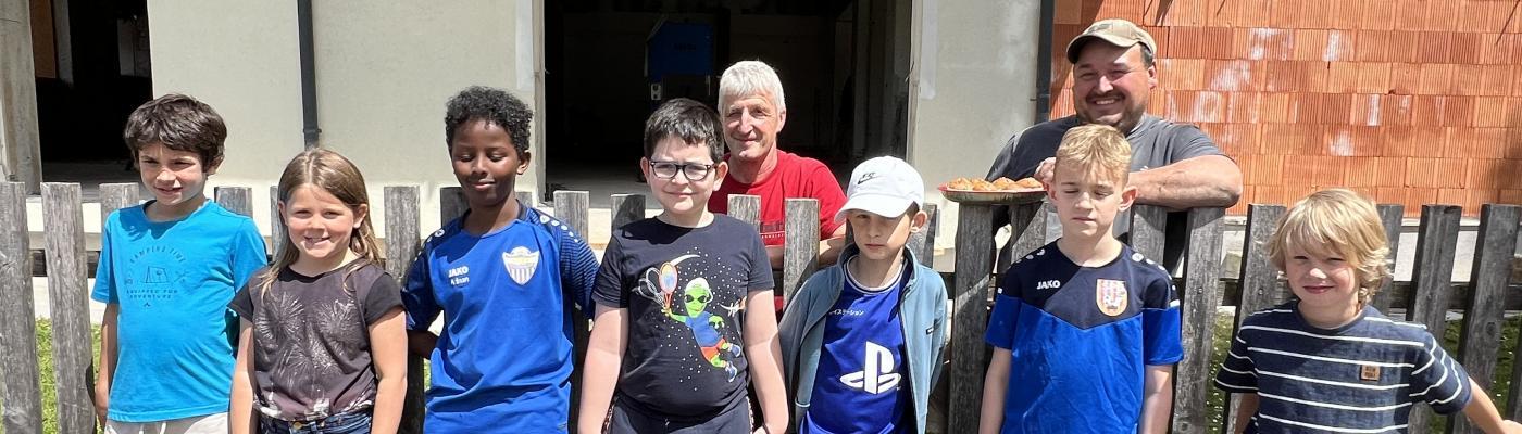 Kinder vor der Baustelle des neuen Hortes mit den Bauarbeitern