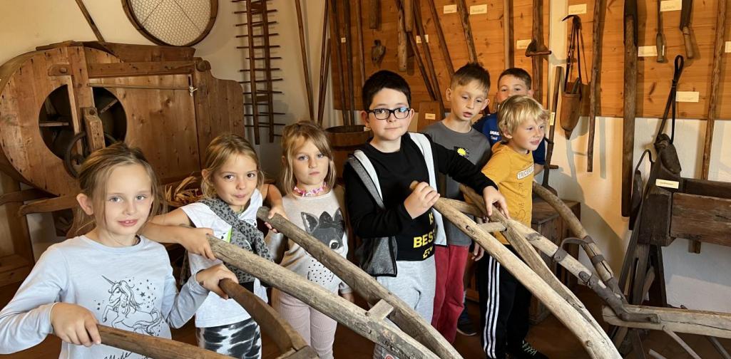 Kinder im Heimatmusem Kinder mit alten Landwirtschaftsgeräten